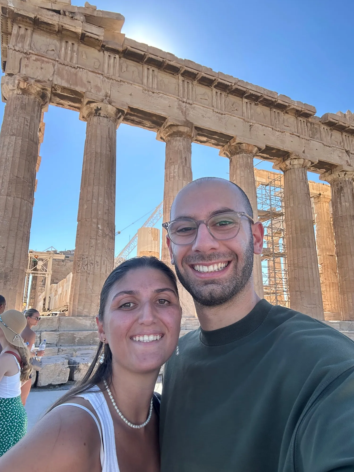 Dana and another person smiling in front of the columns of the Parthenon